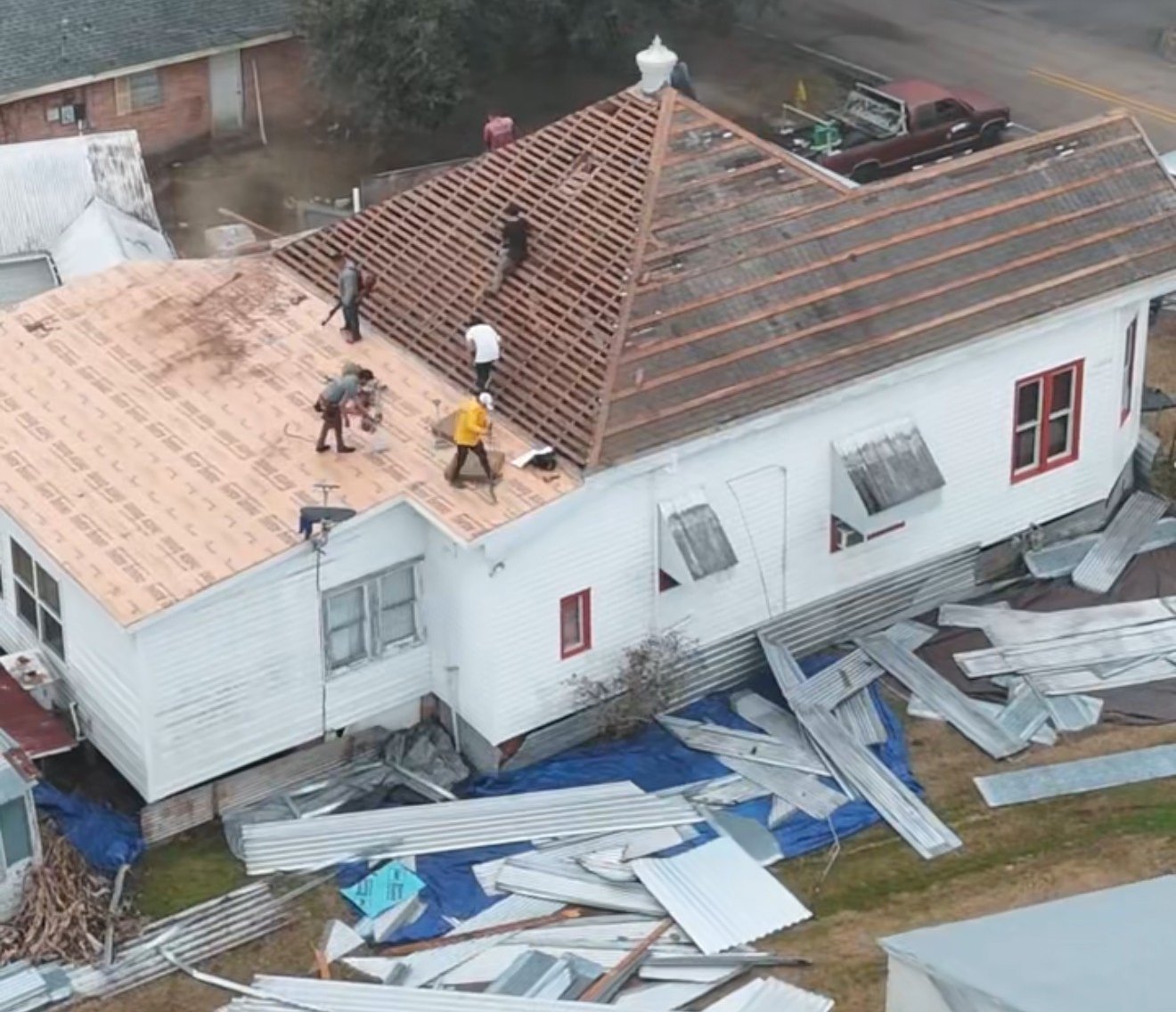 Crew installing architectural asphalt shingles on residential roof in Acadiana