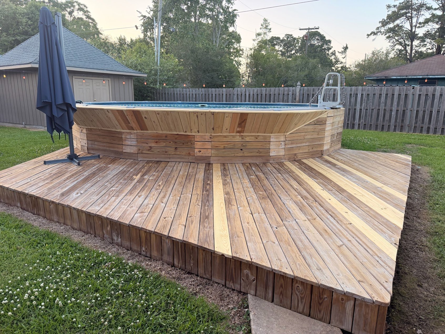 Custom wood deck construction with above-ground pool surround in Louisiana backyard